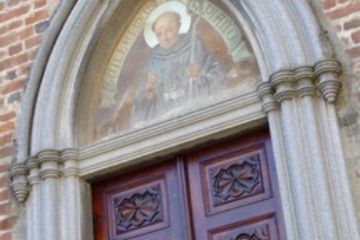 Particolare della Porta Giulia, ingresso laterale della Chiesa  Parrocchiale deo SS. Pietro e Paolo con dipinto dedicato a Guglielmo da Volpiano